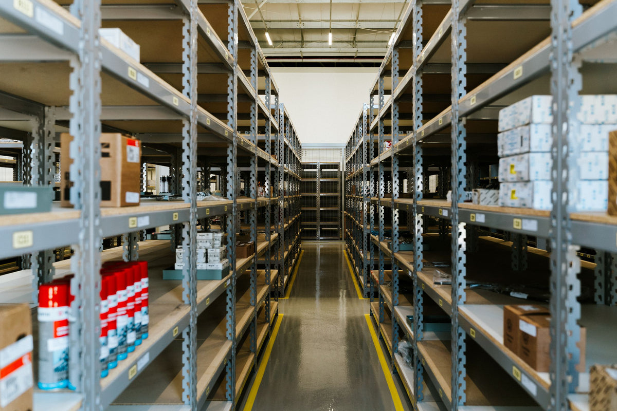 Organized warehouse aisle of labelled parts shelving